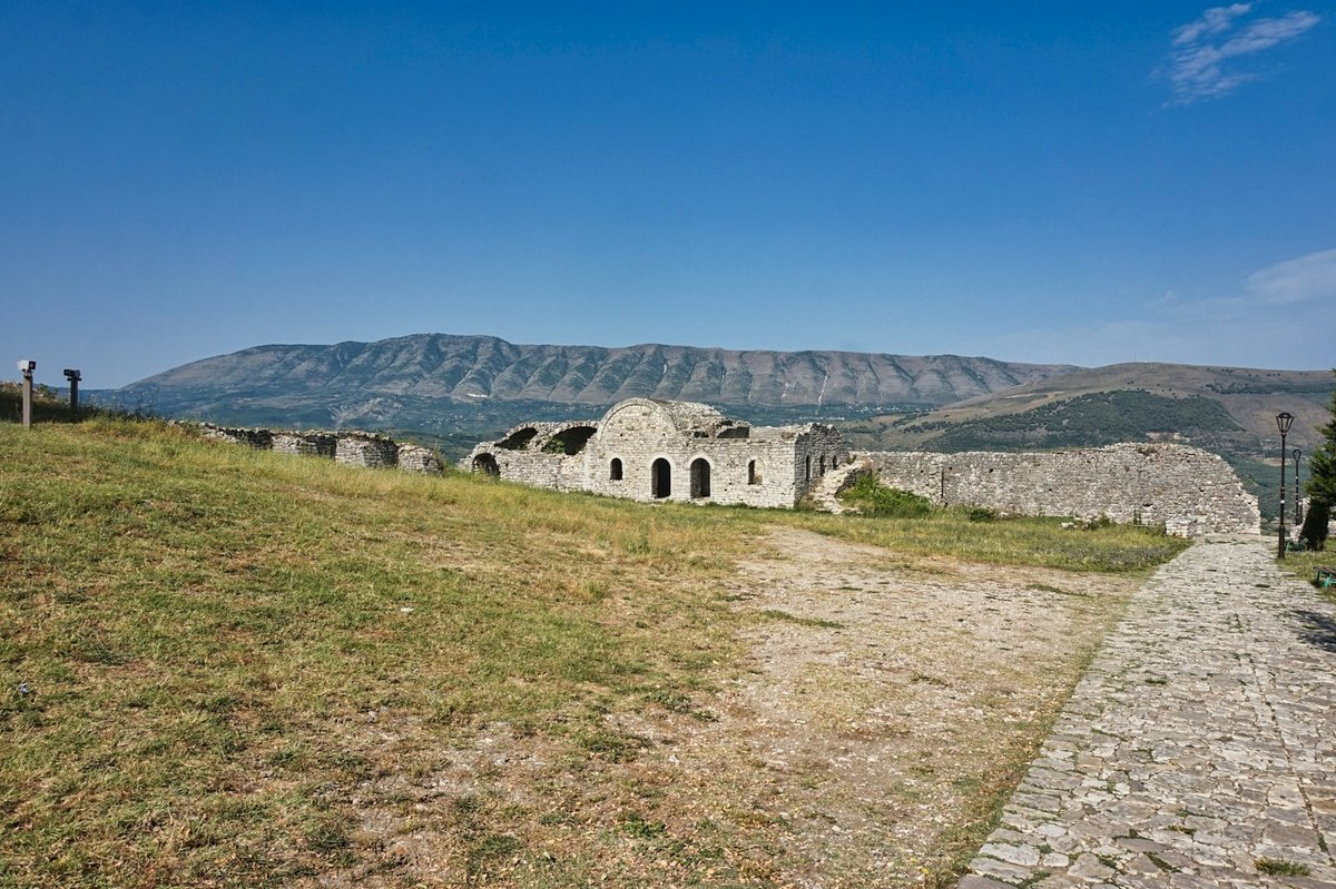 A stone fortress sitting on a rocky green hillside above Berat, Albania