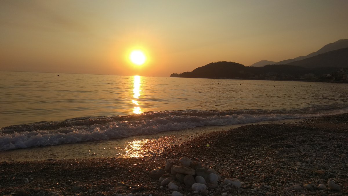 The beach at Potami near Himarë, with buildings along the shore and hills behind