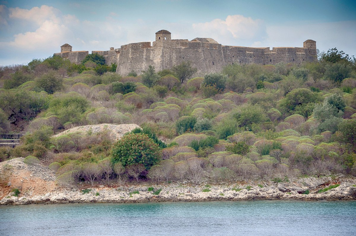 The triangular stone castle of Porto Palermo on a rocky point above a sheltered bay in Albania