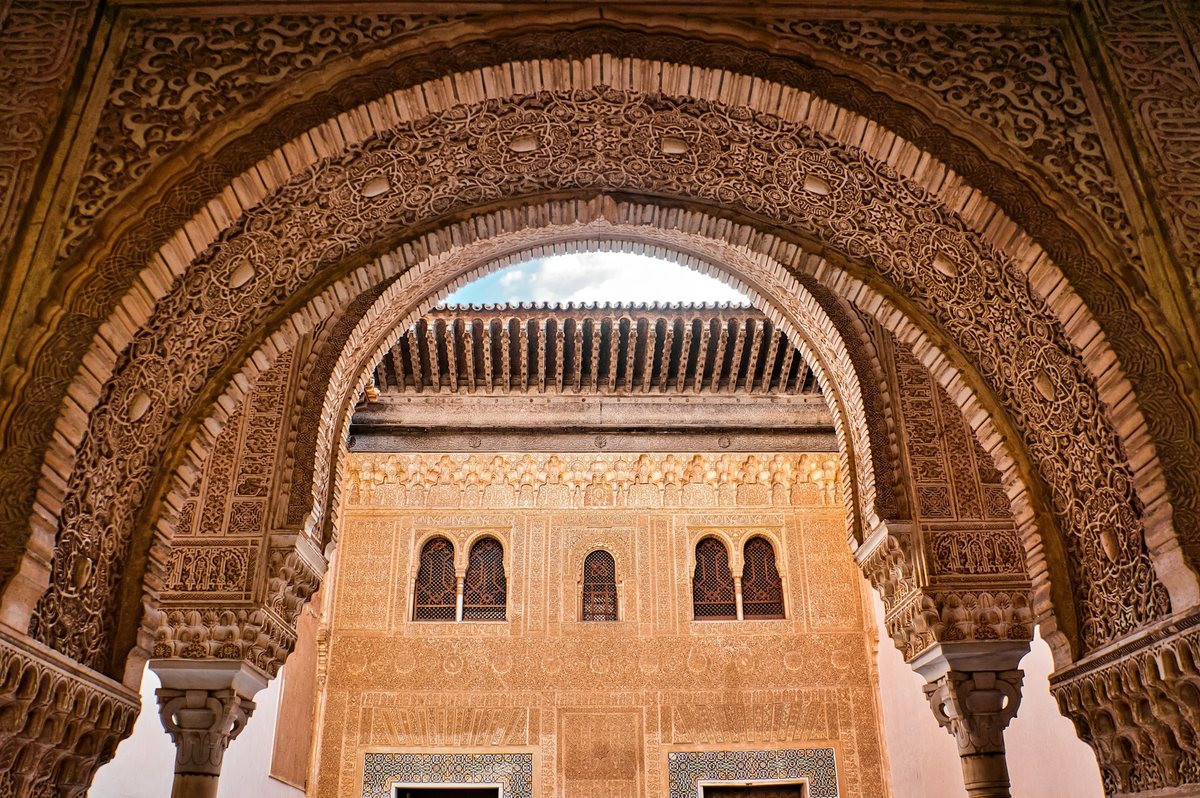 Intricately carved Moorish arch and ornate stucco details inside the Alhambra in Granada