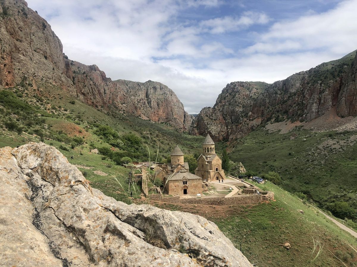 Noravank Monastery's stone churches set in a green gorge beneath red-rock cliffs
