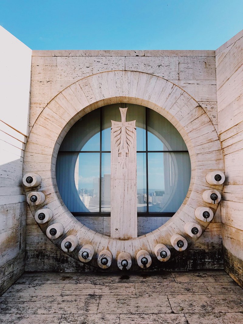 Circular stone fountain with a sculptural relief and surrounding drinking-fountain spouts at Yerevan's Cascade Complex