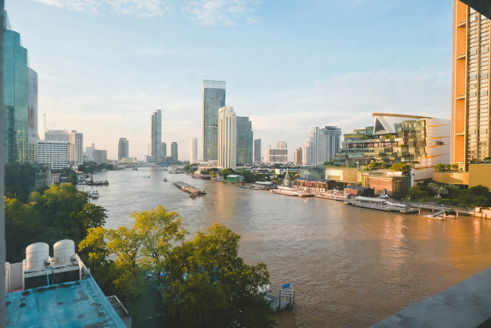 Bangkok skyline with river and boats at sunset