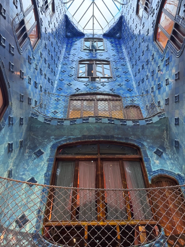 Blue ceramic tile light well inside Casa Batlló, with Gaudí's gradient from deep cobalt to pale turquoise