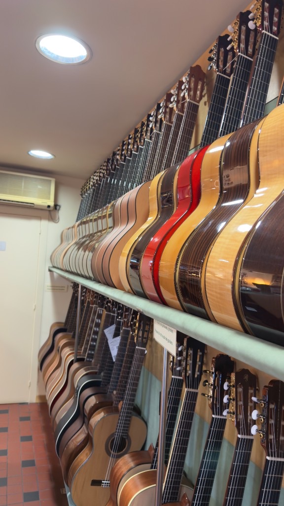 Wall of classical guitars displayed inside Casa Luthier, a specialist guitar shop in Barcelona