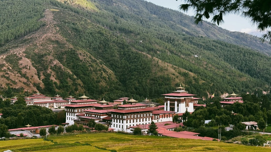 Tashichho Dzong in Thimphu with white walls, red roofs and forested mountains behind