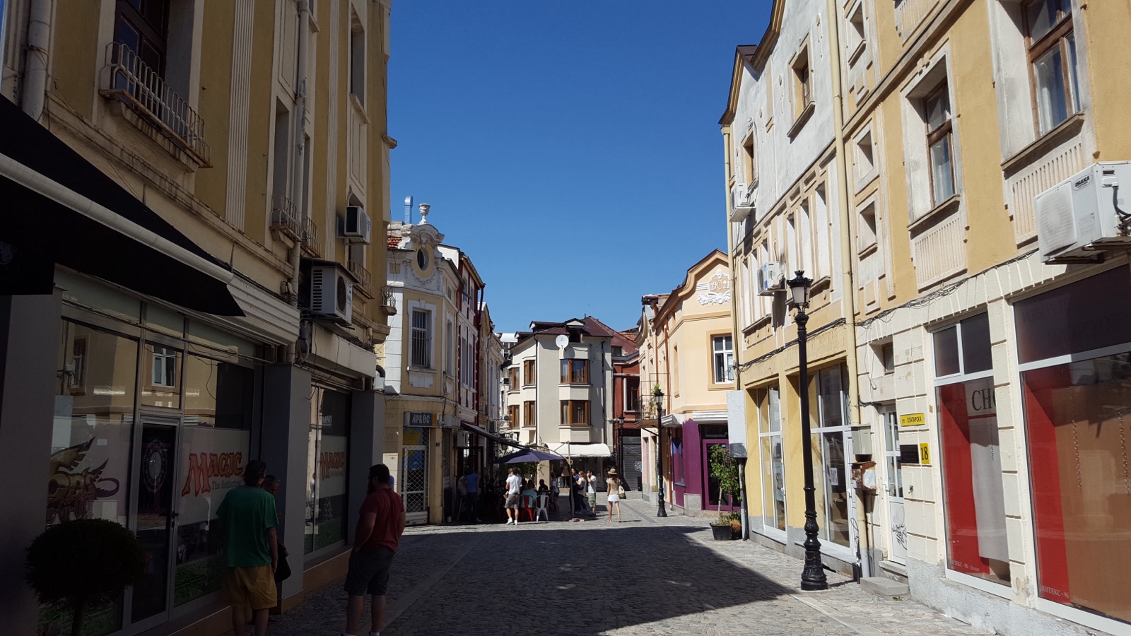 Narrow cobblestone street in Kapana, Plovdiv, lined with shops and cafés