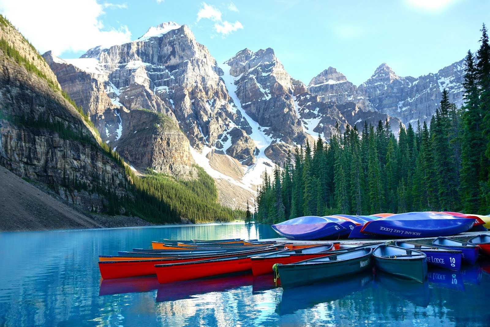 Colourful canoes on turquoise glacial lake waters in Banff National Park