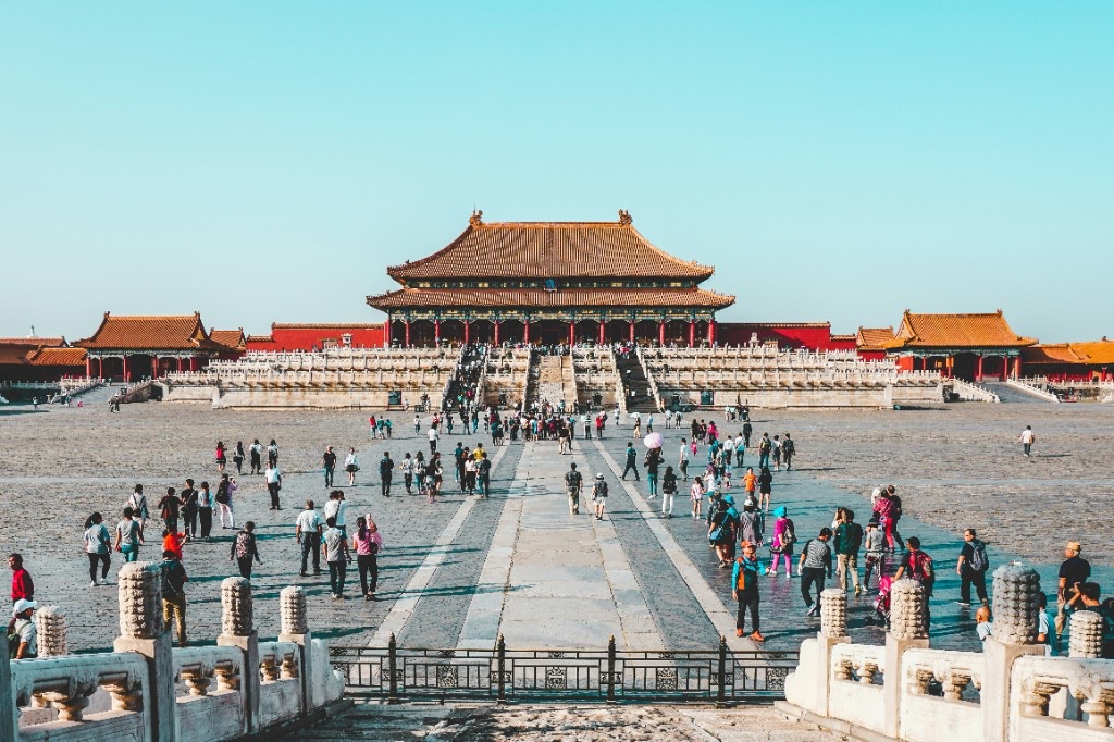 Courtyard of the Forbidden City in Beijing with yellow-tiled imperial halls and visitors