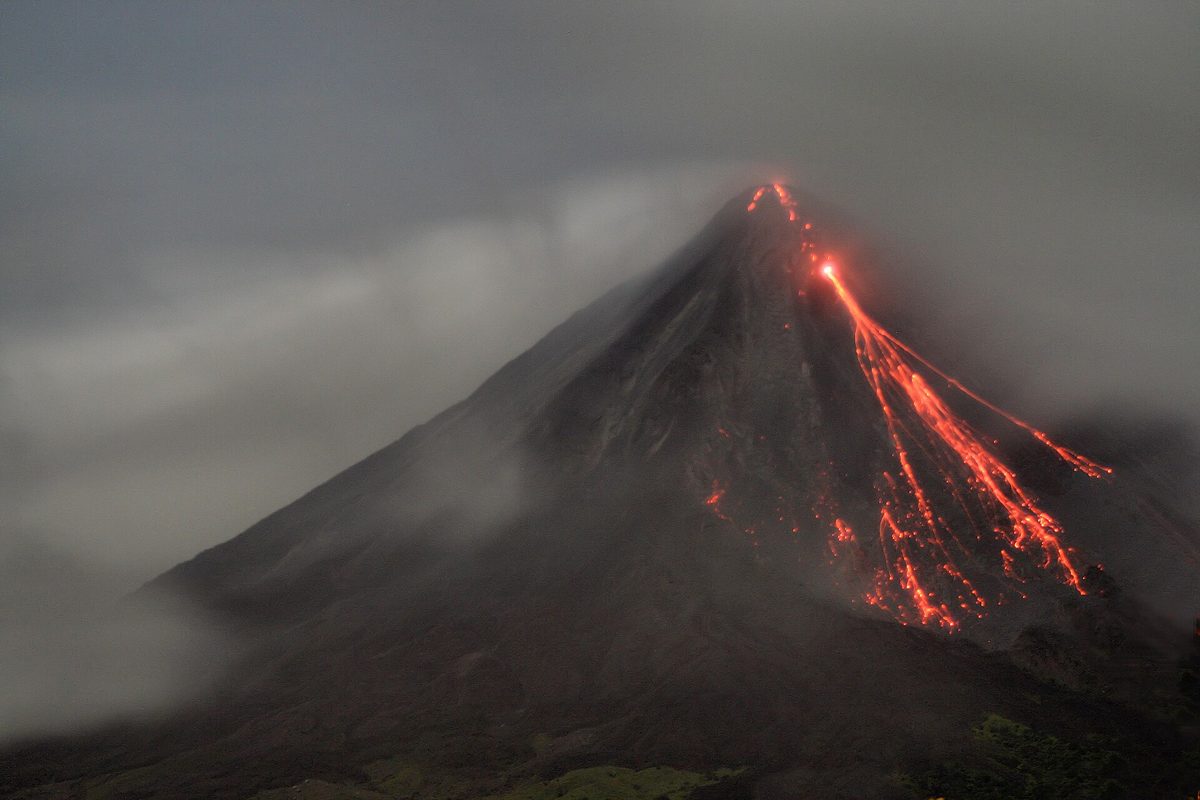 Historical photo of Arenal Volcano erupting at night with glowing lava, from its active period before 2010