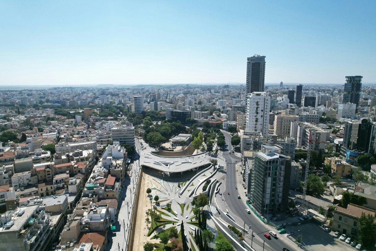 Aerial view of central Nicosia with low-rise buildings, a few towers and the curved modern structure of Eleftheria Square
