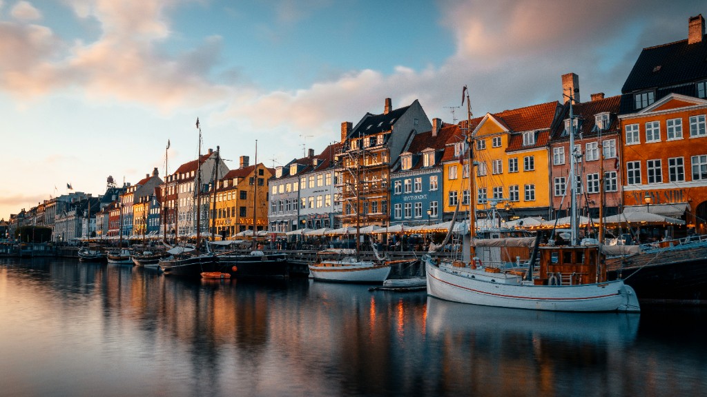 Colourful townhouses and boats along Nyhavn harbour in Copenhagen at golden hour