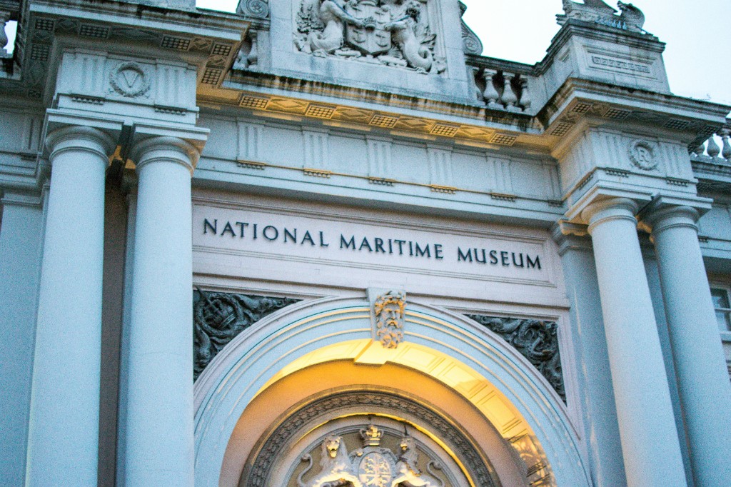 Illuminated neoclassical entrance of a national maritime museum at dusk