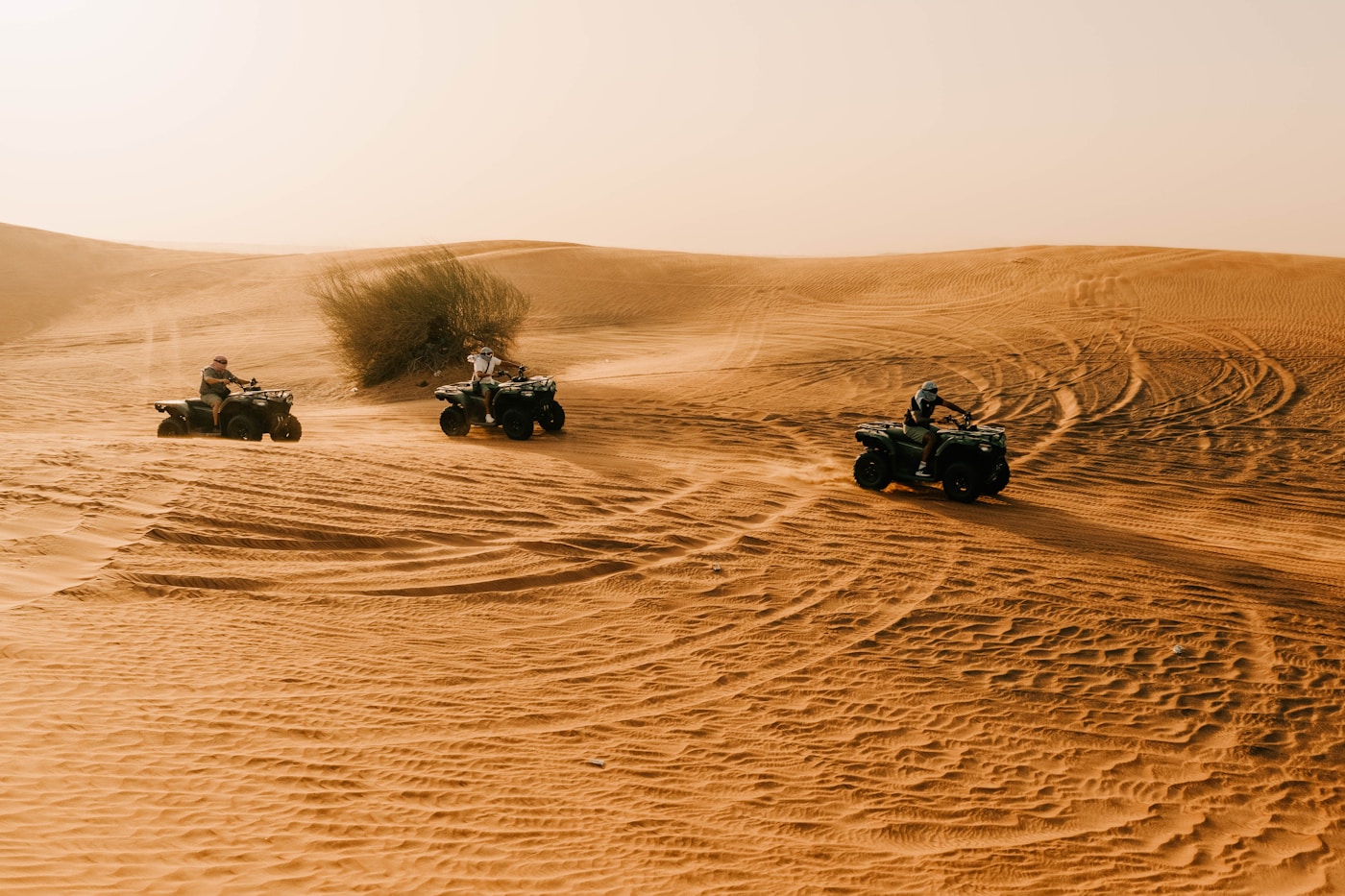 ATVs riding across sand dunes in the Dubai desert