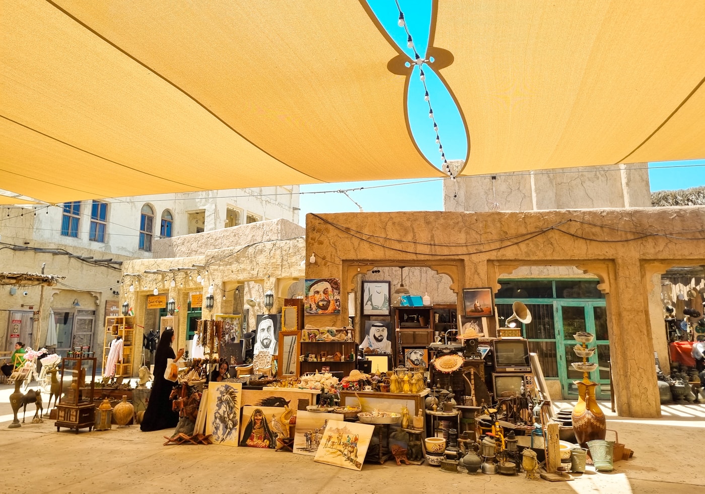 Colorful items displayed under a yellow umbrella in a Dubai market