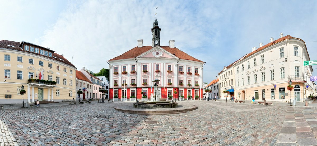 Place de l’Hôtel de ville à Tartu, hôtel de ville rose, pavés et fontaine des Étudiants qui s’embrassent