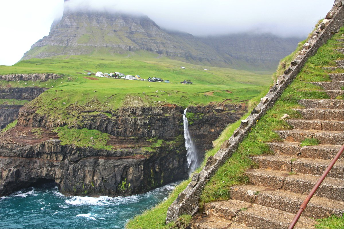 Gásadalur village and Múlafossur waterfall on a grassy cliff above the Atlantic on Vágar