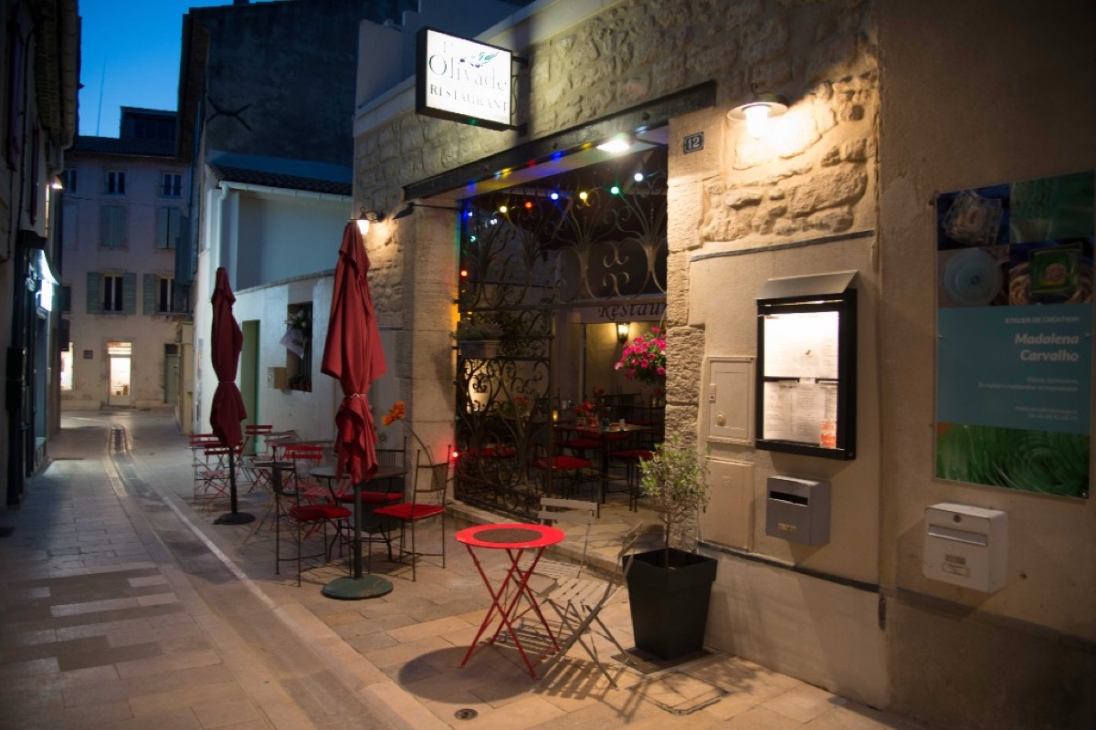 A cozy evening restaurant terrace on a narrow lane in Saint-Remy-de-Provence