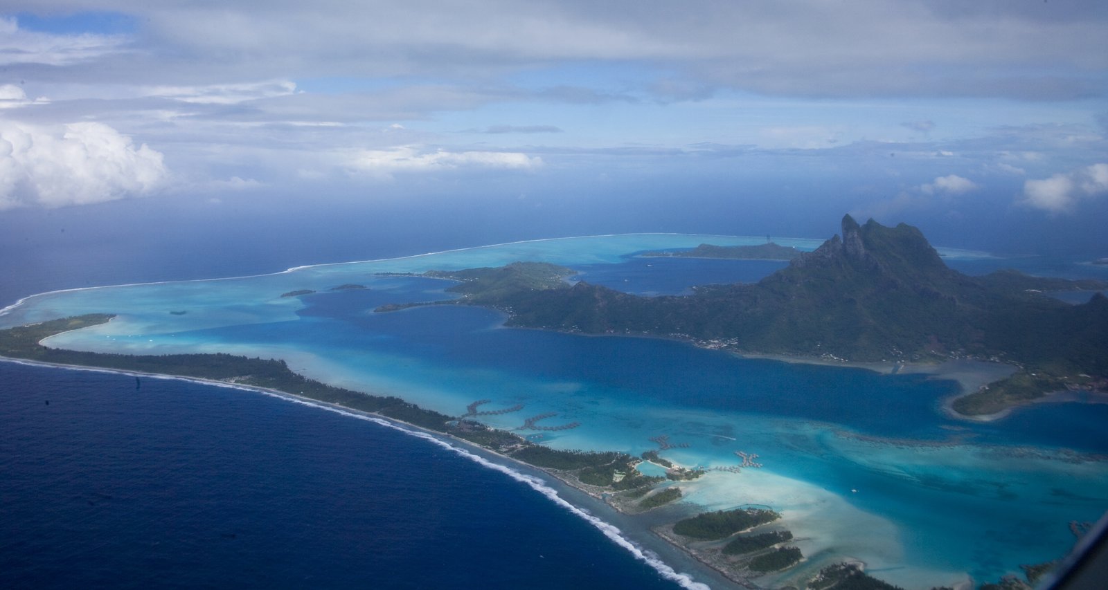 Vista aérea de la laguna turquesa de Bora Bora, islotes de arrecife y el monte Otemanu en la isla principal