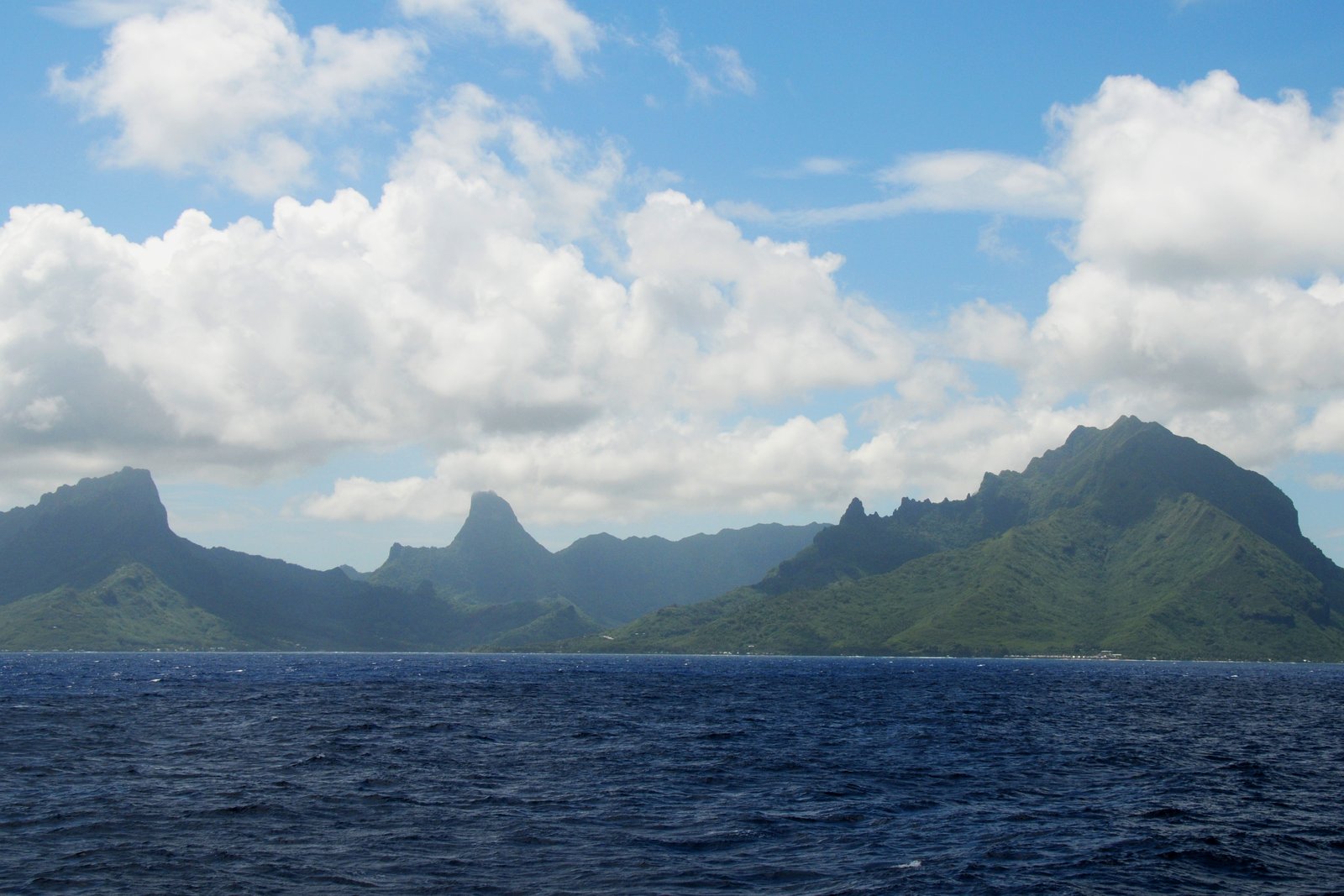 Entrada del arrecife y agua turquesa en Cook’s Bay en Moorea, con montañas verdes detrás de la laguna