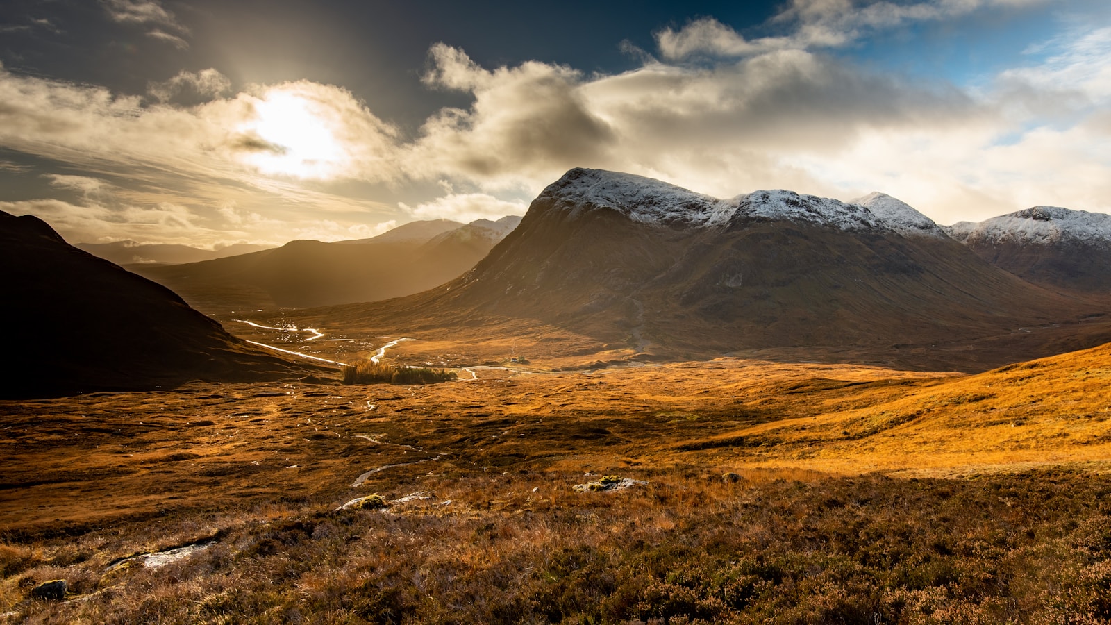 Dramatic brown mountain peaks of Glencoe in the Scottish Highlands under open sky