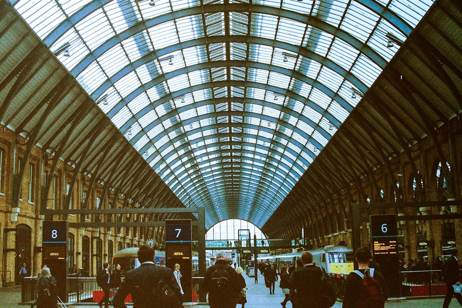 Interior of King's Cross Station in London with arched roof and busy platforms