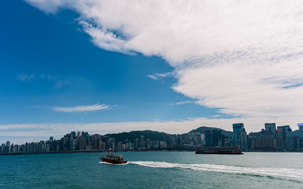 Victoria Harbour in Hong Kong with boats crossing the water and city skyline beyond