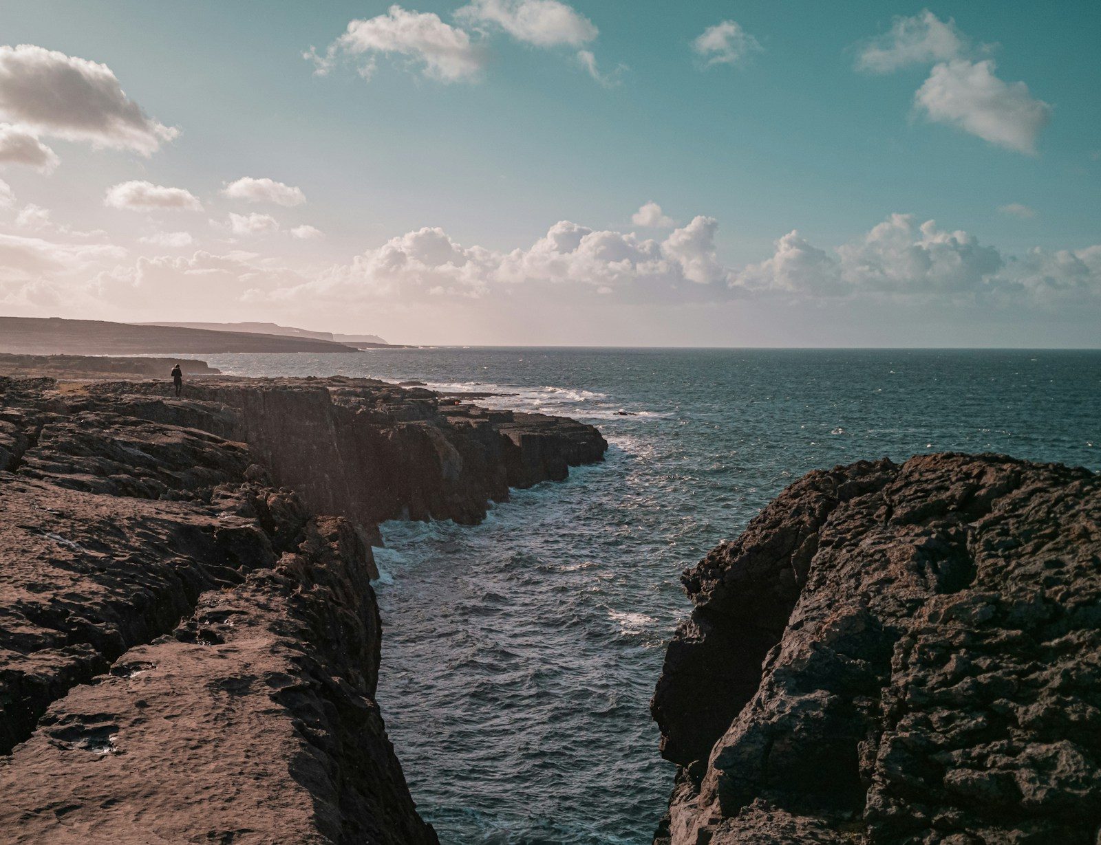 Rocky limestone hills of the Burren beside the sea under a cloudy sky