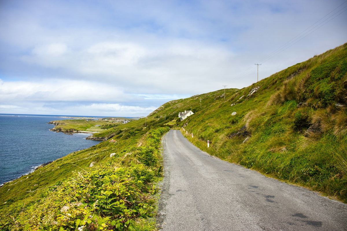 A winding road along a green coastal hillside on Ireland's west coast