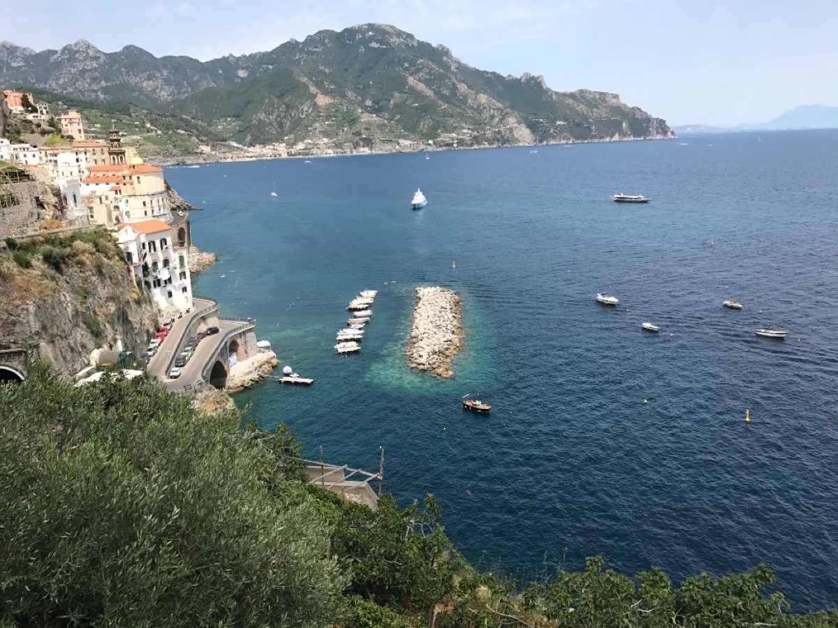 Sweeping view over a coastal village, boats, and the deep blue Mediterranean from high on the Amalfi Coast