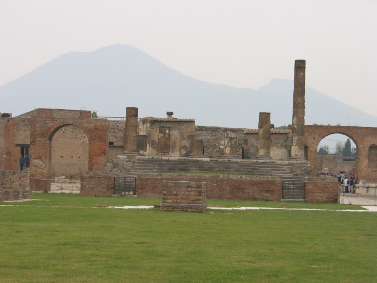 Ruins of the Temple of Jupiter in Pompeii's Forum with Mount Vesuvius rising in the distance