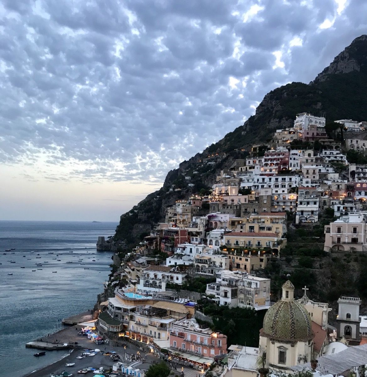 Positano's pastel-coloured houses cascading down the cliffs to the sea at dusk