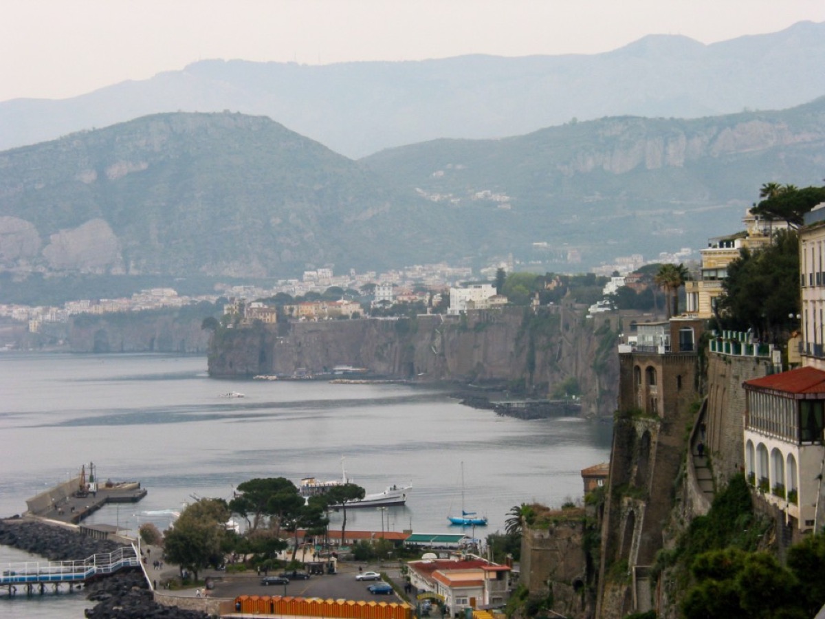 Sorrento's cliffs and buildings above the Bay of Naples with mountains in the distance