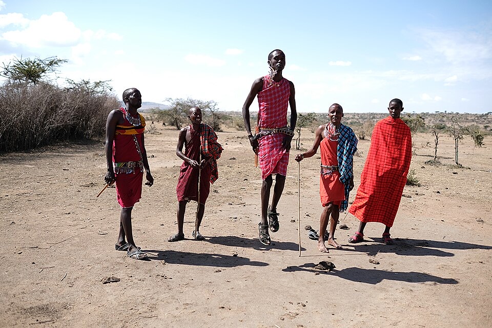 Maasai men performing the adumu jumping dance during a village visit in Maasai Mara, Kenya