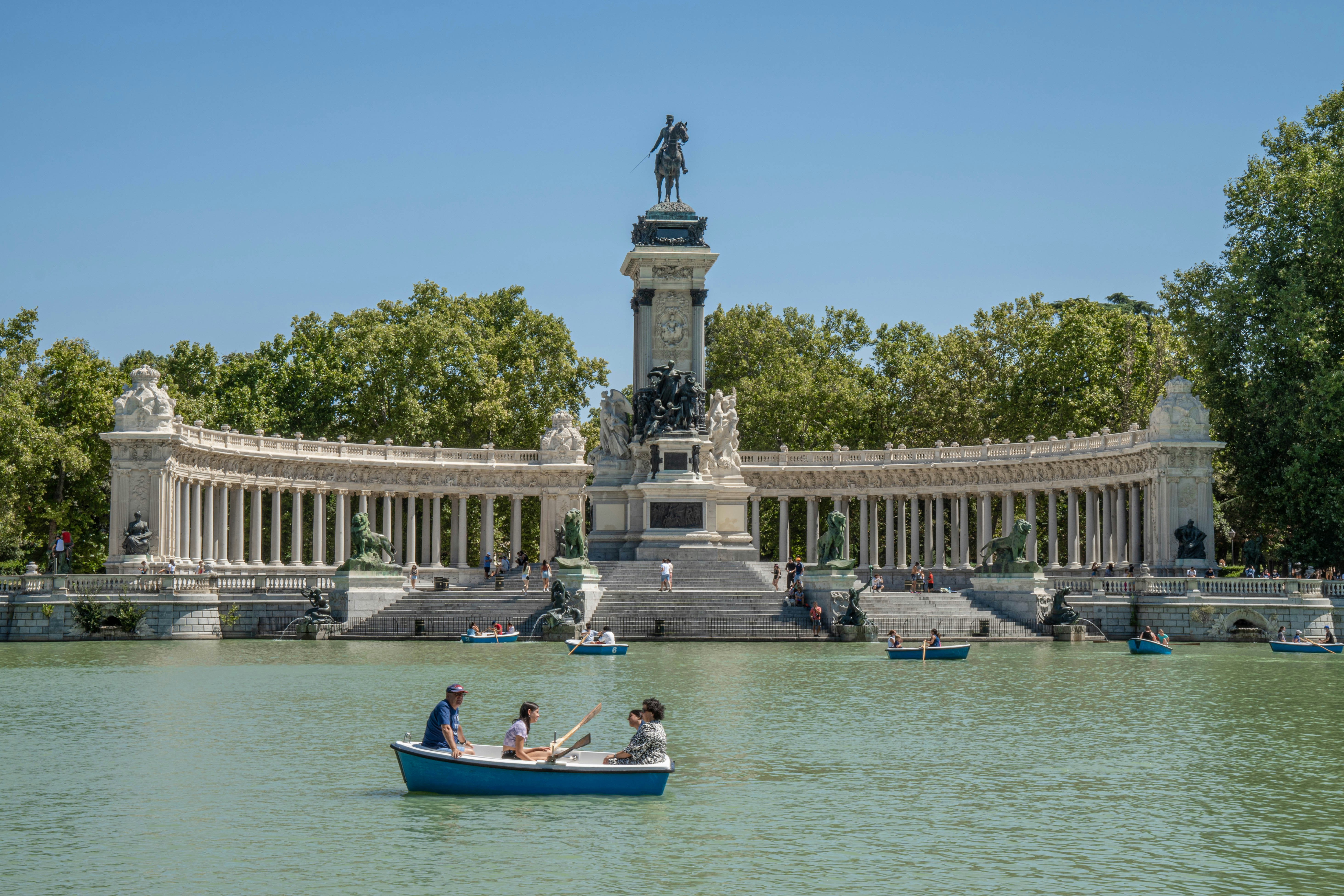 Retiro Park in Madrid with trees, lake, and people relaxing