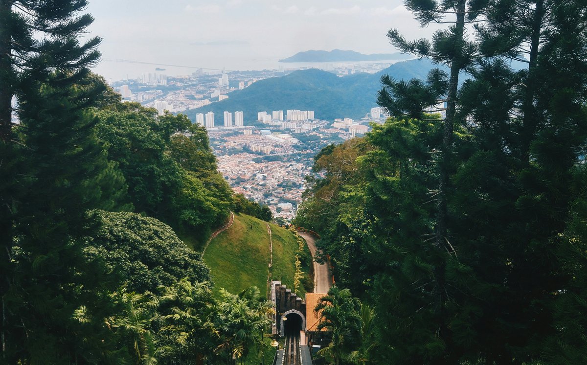 View from Penang Hill through green forest toward George Town and the sea