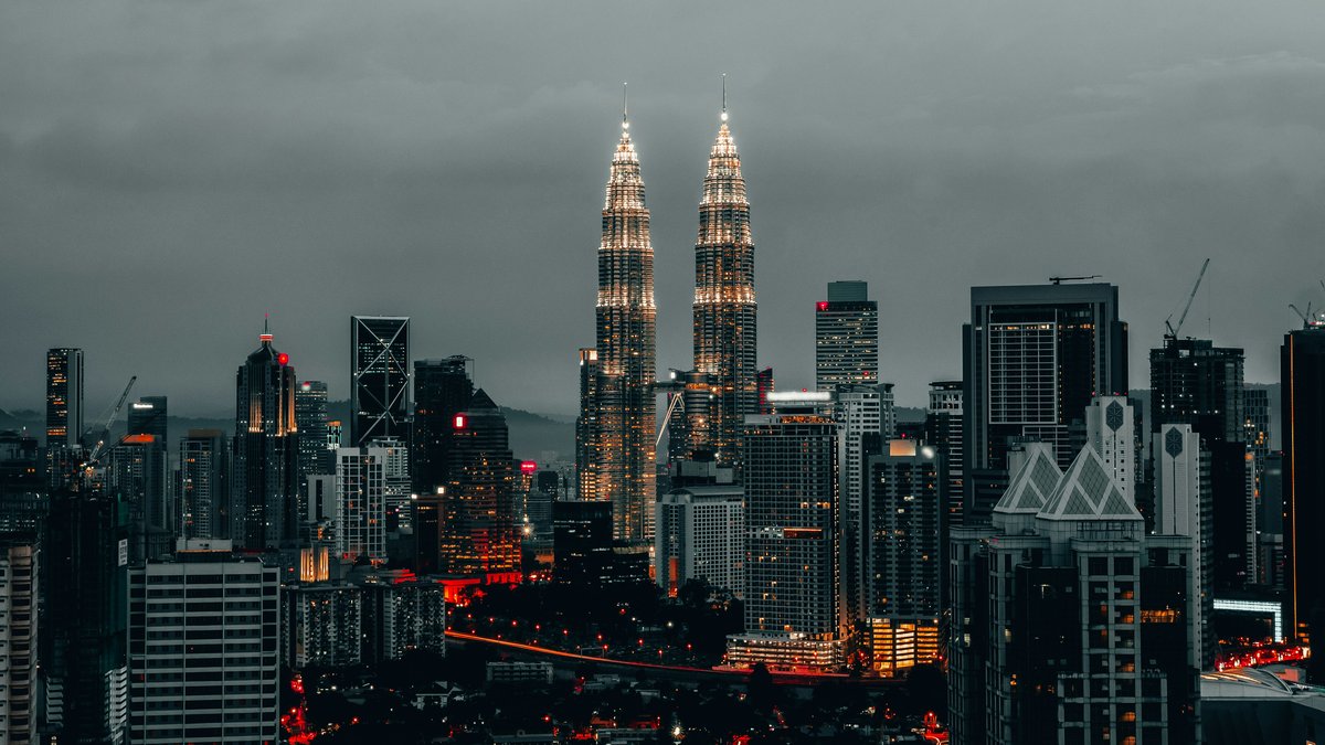 The Petronas Twin Towers rising above Kuala Lumpur's skyline at dusk