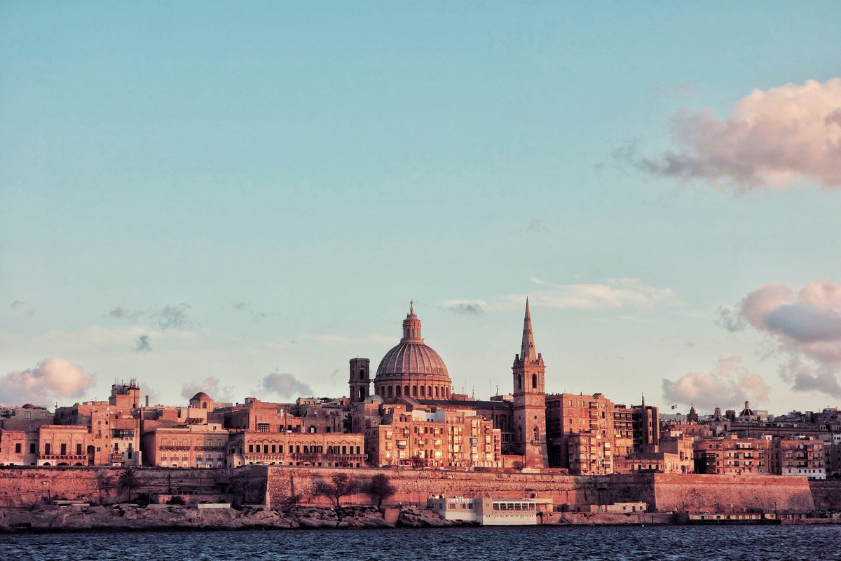Panoramic view of Valletta at sunset, with its domes, church spires and limestone skyline above the harbour