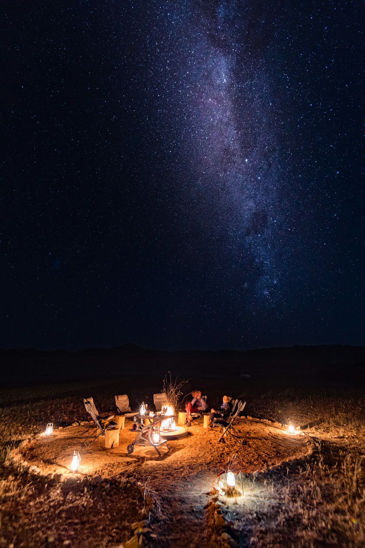 Campfire under the Milky Way in the Namibian desert night sky