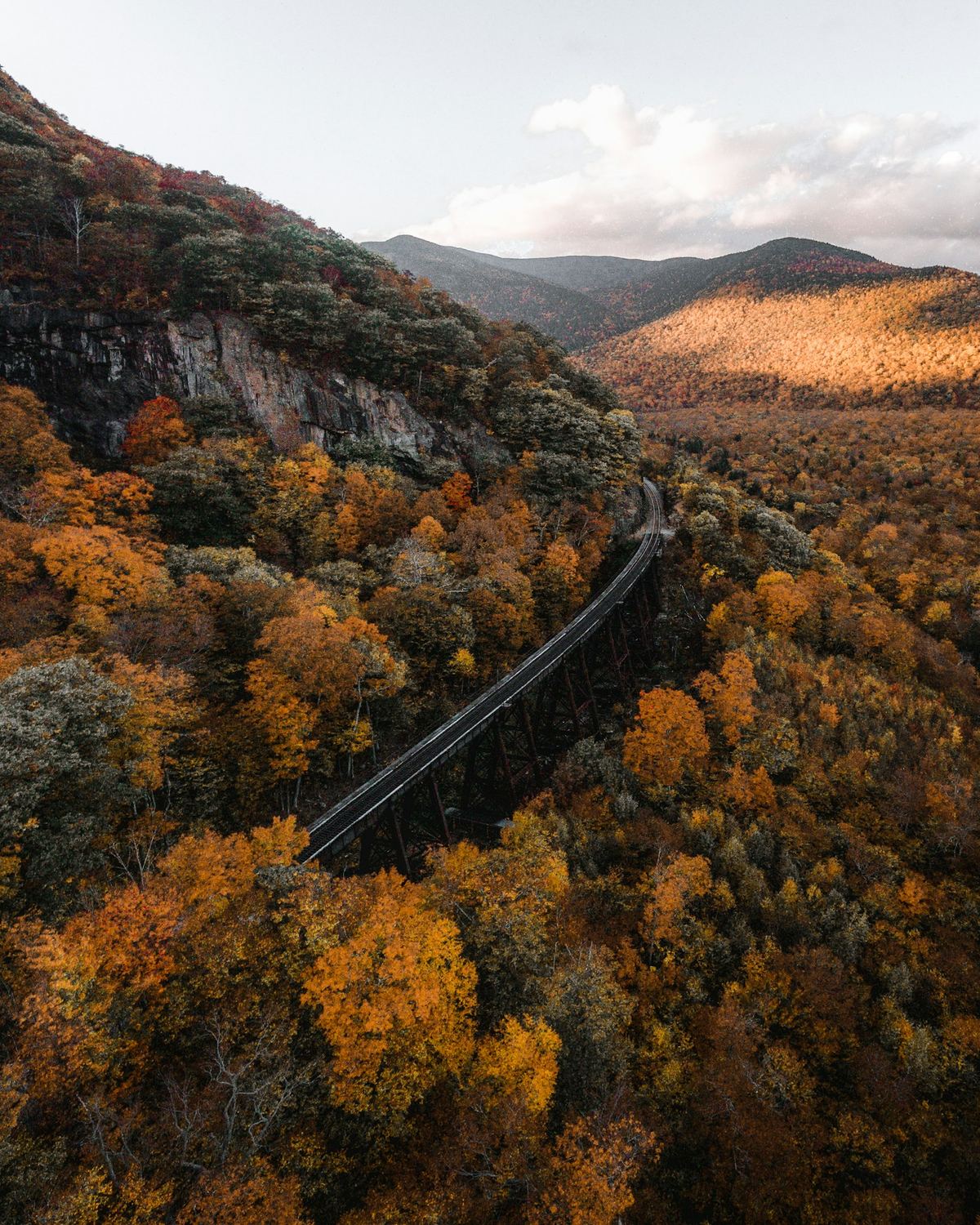 Aerial view of the Frankenstein Trestle through autumn-covered mountains of Crawford Notch