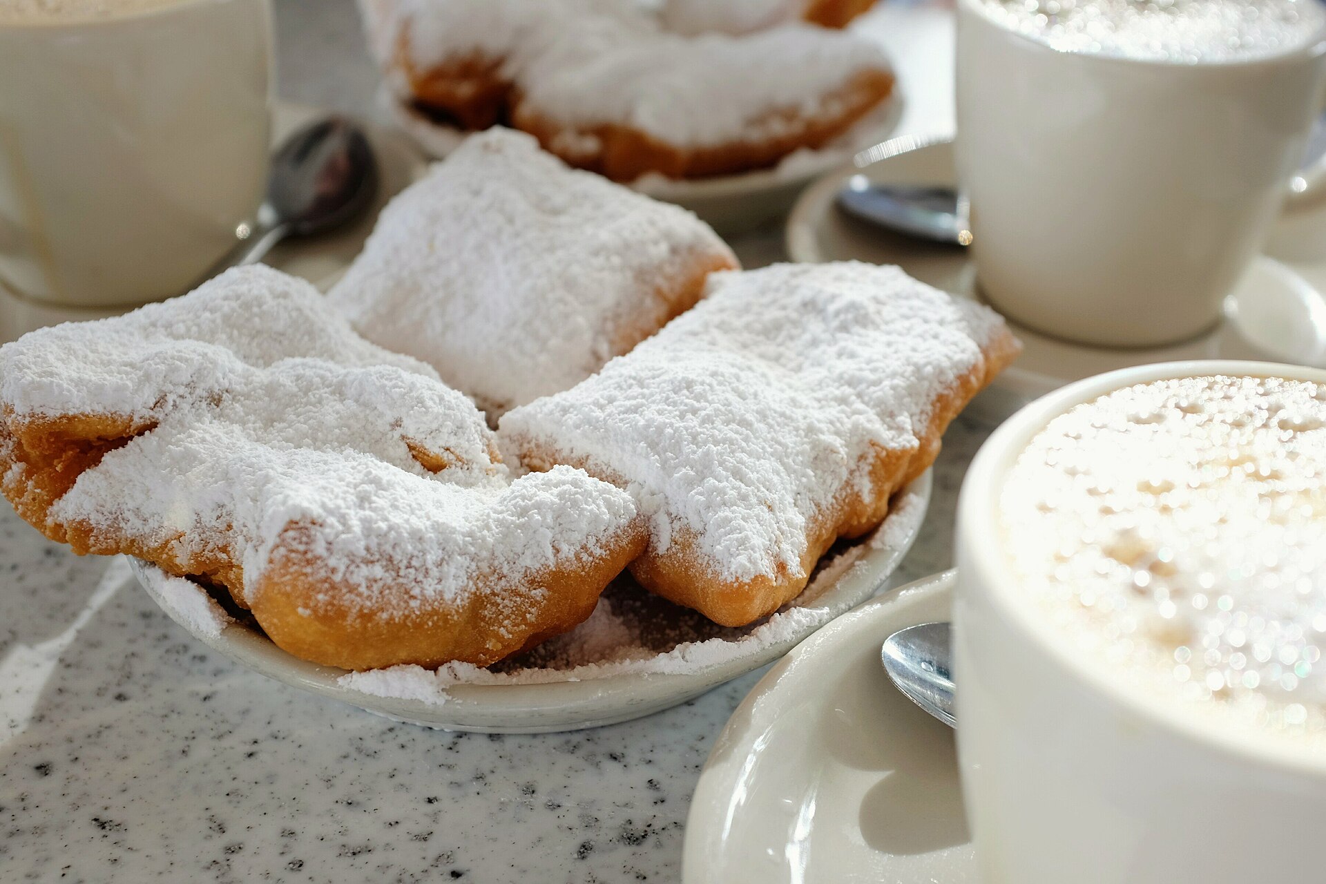 Beignets dusted with powdered sugar and café au lait at Café du Monde in New Orleans