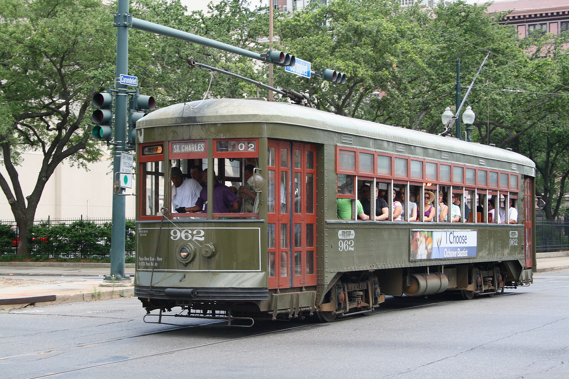 Historic streetcar traveling along a tree-lined avenue in New Orleans