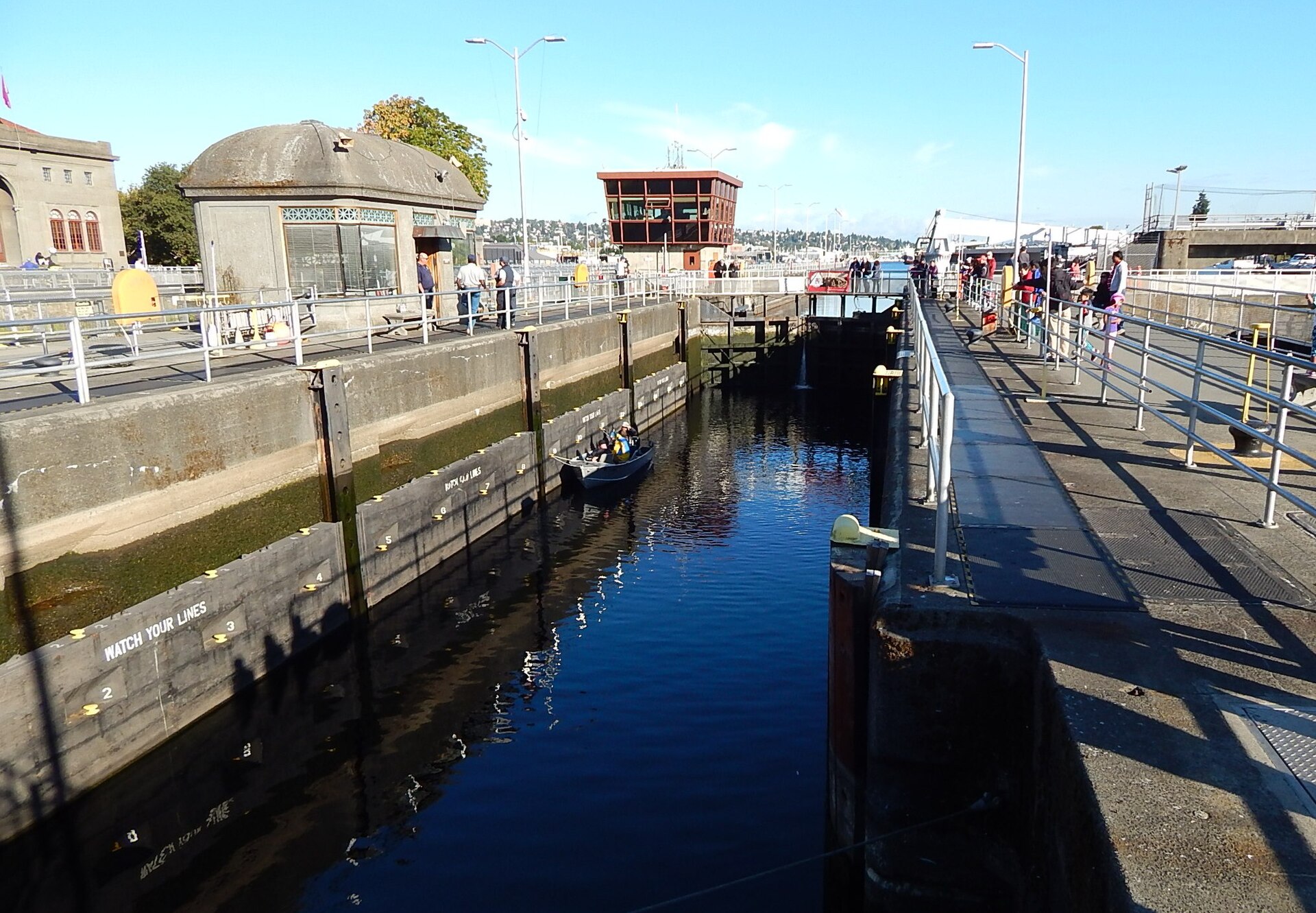 The Hiram M. Chittenden Locks in Seattle showing a boat passing through the canal lock with visitors watching from the sides