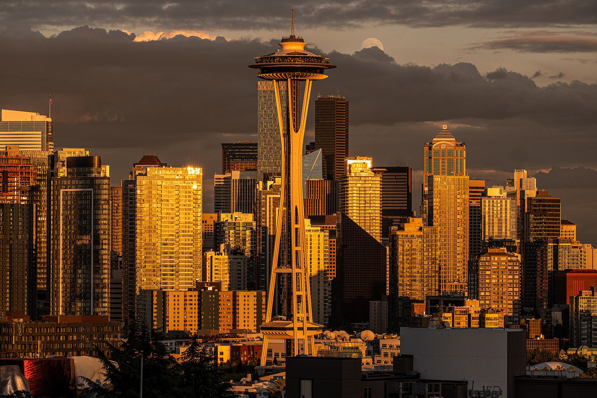 The Seattle skyline at dusk featuring the illuminated Space Needle surrounded by downtown skyscrapers beneath a deep blue evening sky