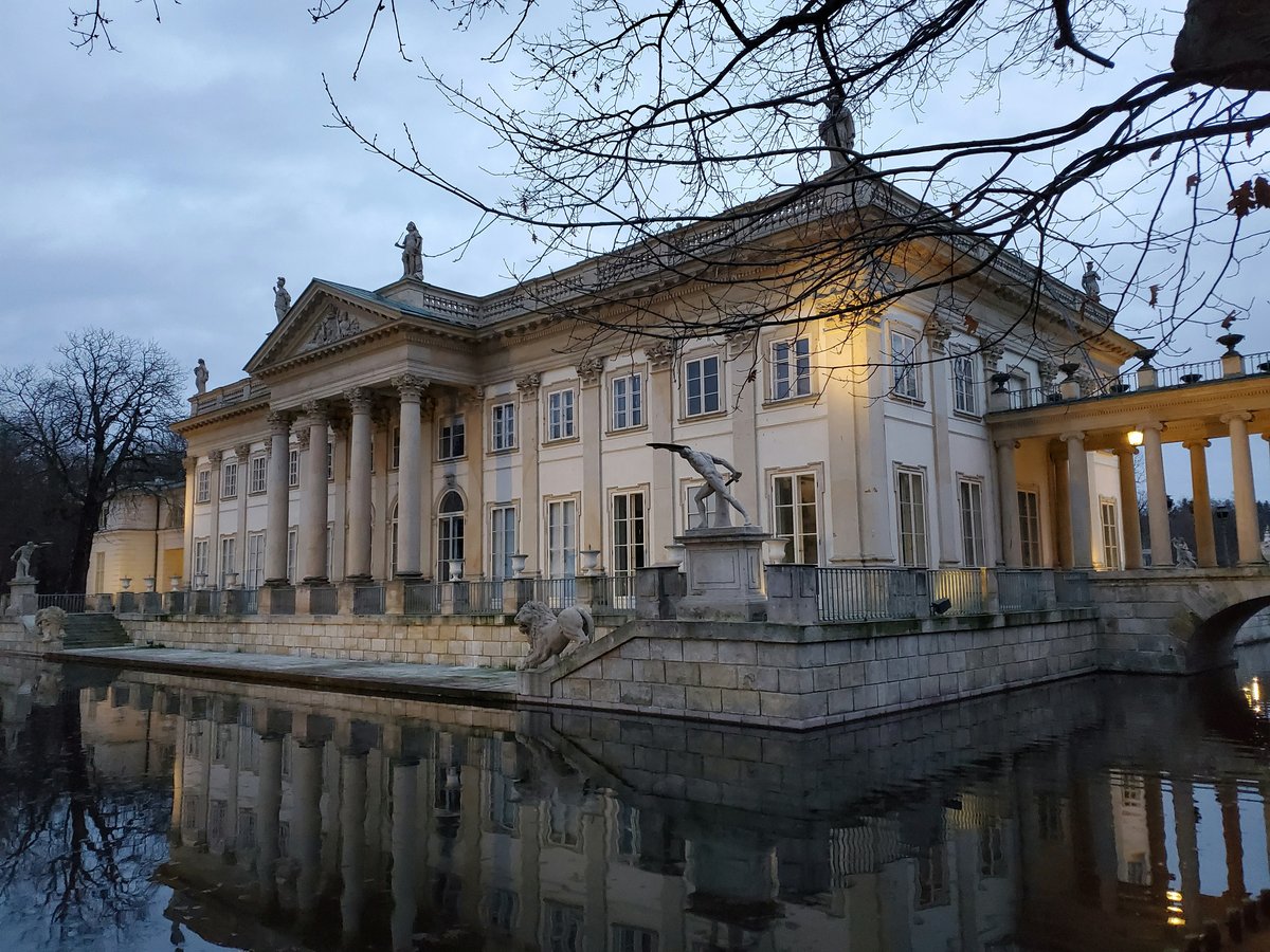 The Palace on the Isle in Łazienki Park, Warsaw, reflected in the water and framed by bare winter branches