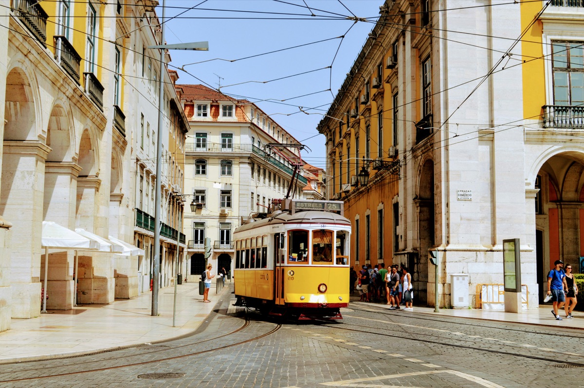 Historic yellow Tram 28 passing through Alfama in Lisbon