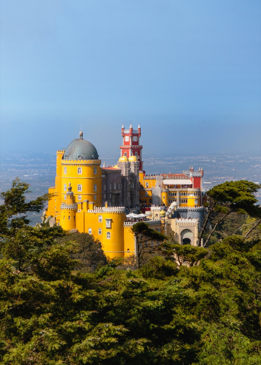 Colourful Pena Palace on a lush green hillside above Sintra, Portugal