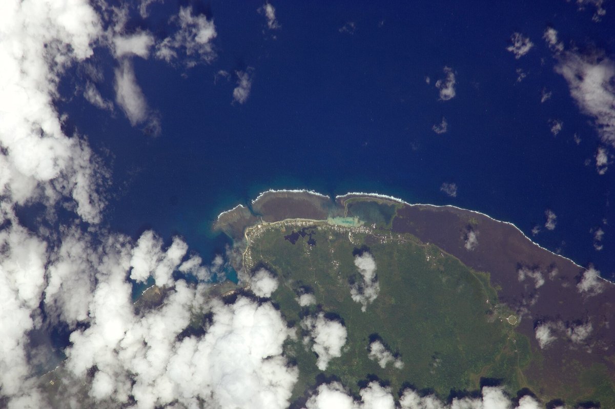 Astronaut photograph of Savai‘i's central north coast, showing dark lava-field areas, reefs and scattered cloud