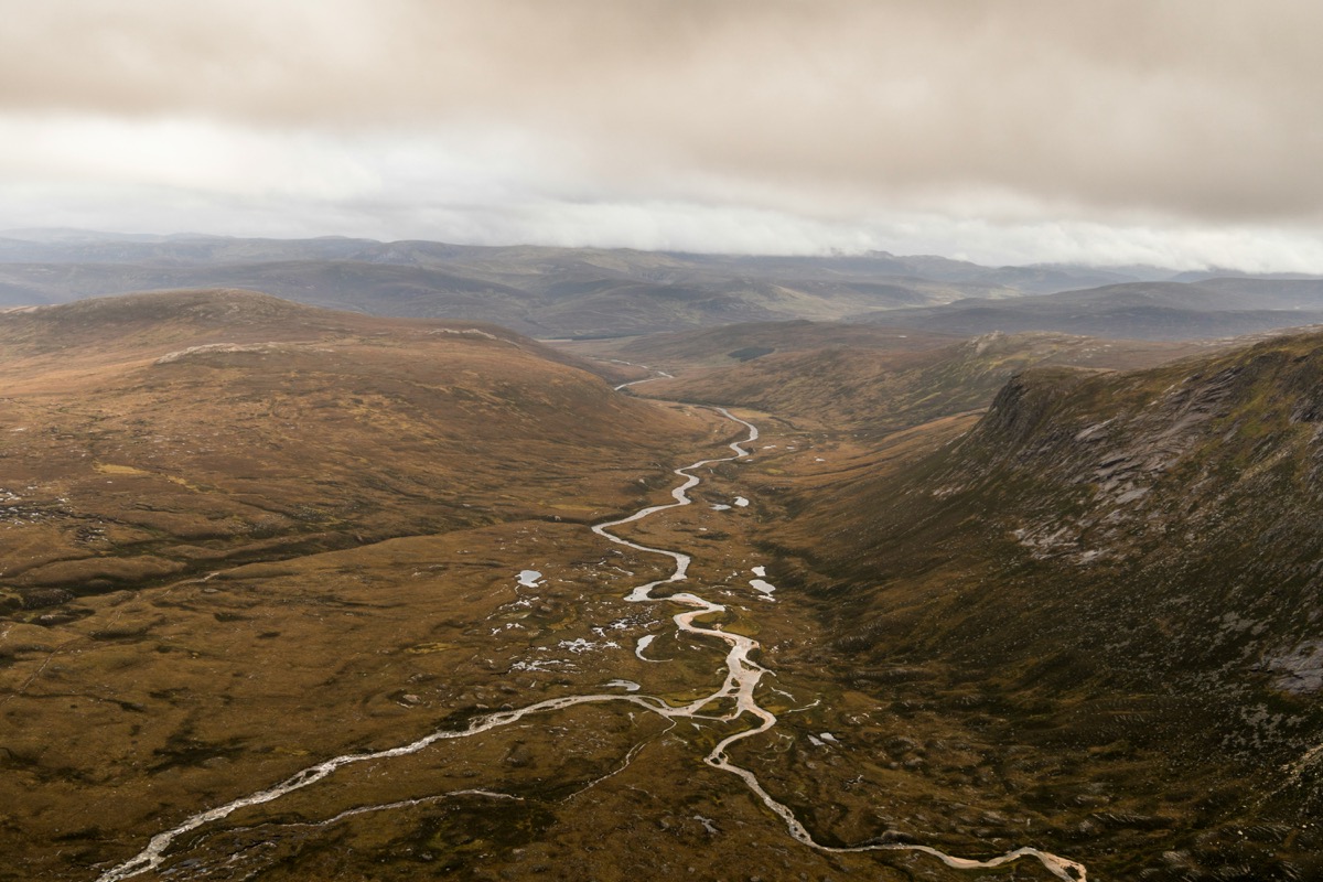 Aerial view of a winding road and the River Dee through Cairngorms National Park