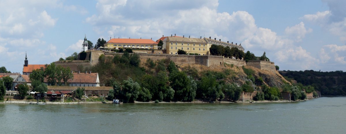Wide view of Petrovaradin Fortress above the Danube in Novi Sad, with the clock tower and river in the distance